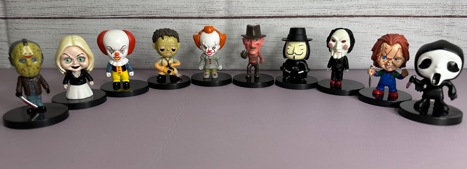 Row of small figurines on a gray surface