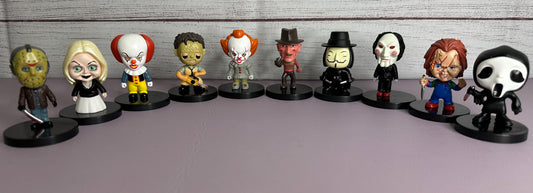 Row of small figurines on a gray surface